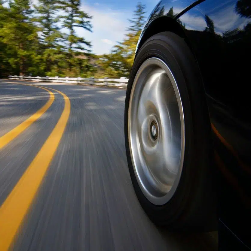 car wheel in motion and continuous double yellow lines