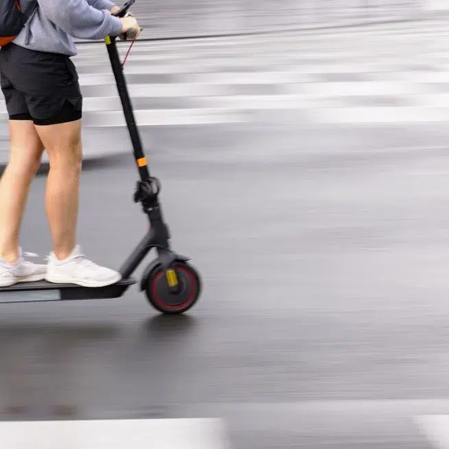 motion blur picture of an unrecognizable person with an electric scooter on a city street. High speed